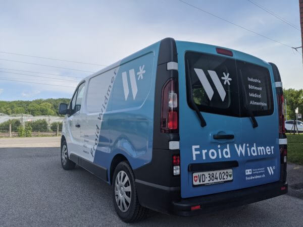 Camionnette bleue de Froid Widmer stationnée, vue de dos.