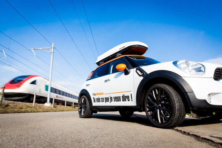Vu de côté d'une voiture Mini Cooper avec le logo et le slogan de l'entreprise PubAdhesive