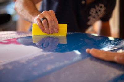 Application de vinyle sur carrosserie bleu.