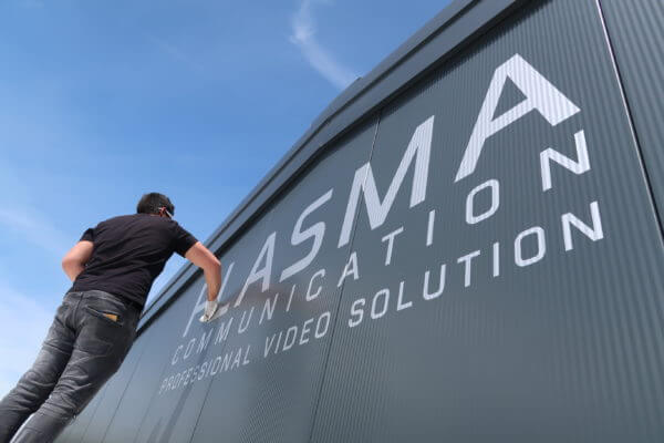 Homme installe une enseigne de communication.