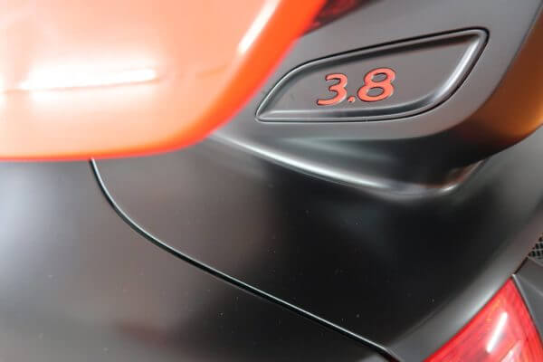 Voiture noire avec inscription 3.8 rouge.