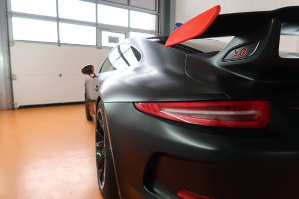 Voiture de sport noire dans un garage.