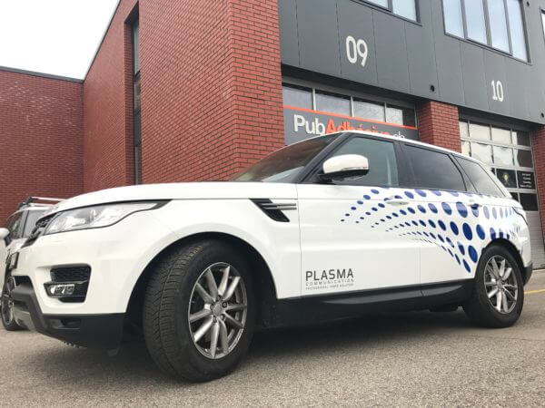 Véhicule de sport blanc garé devant un bâtiment.