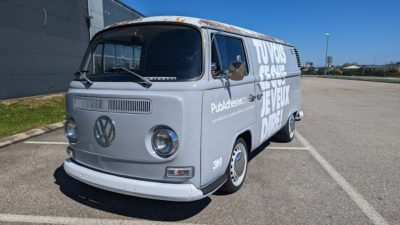 Fourgon VW classique stationné sur un parking.