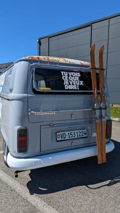 Van avec skis et autocollant humour.