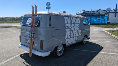 Fourgon vintage avec texte humoristique, skis attachés.