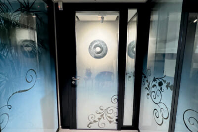 Porte vitrée avec motifs floraux et intérieur lumineux.