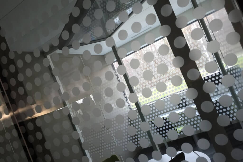 Mur vitré avec motifs de ronds blancs.