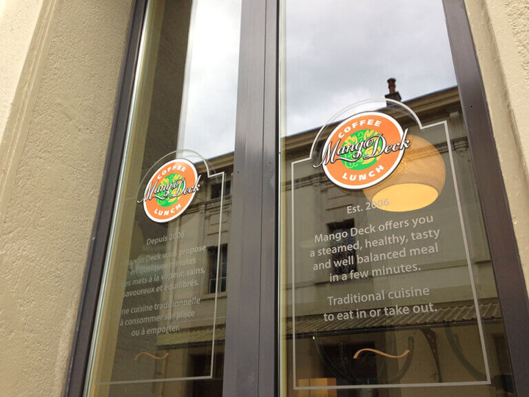 Fenêtre d'un café avec logo Mango Deck.