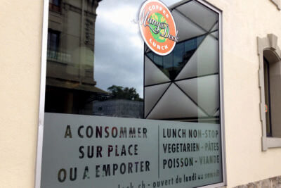 Fenêtre restaurant avec menu et horaires.