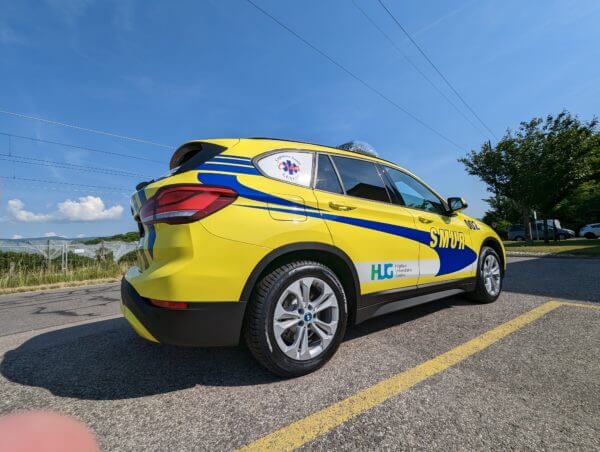 Voiture de secours jaune et bleue sur route.