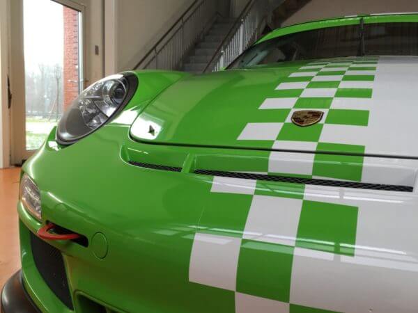 Voiture de sport verte avec motif à carreaux.