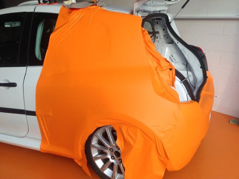 Voiture partiellement recouverte de tissu orange.