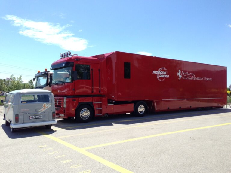 Camion rouge et van gris garés.