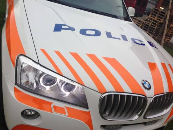 Voiture BMW de police avec bandes orange.