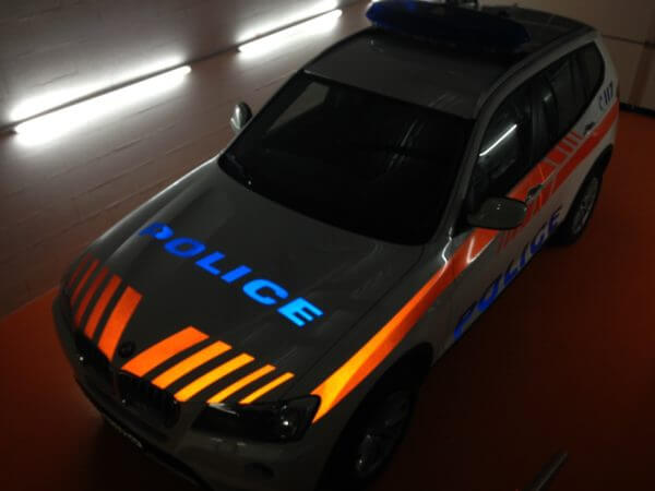 Voiture de police avec bandes orange et bleues.