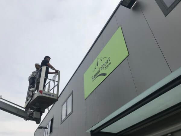 Installation enseigne Raoul Sport sur façade de bâtiment.