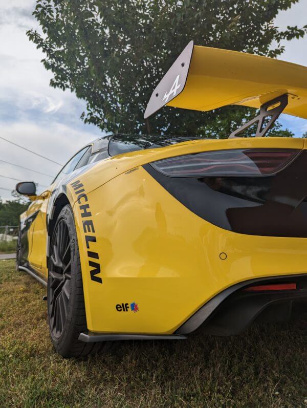 Voiture de sport jaune avec aileron arrière.
