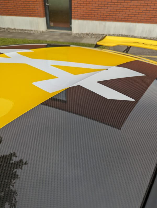 Capot de voiture avec motif blanc sur fond jaune.