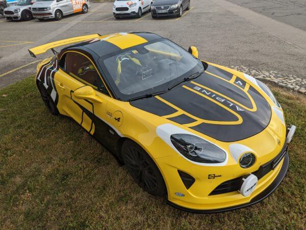 Voiture de sport jaune et noire sur l'herbe.