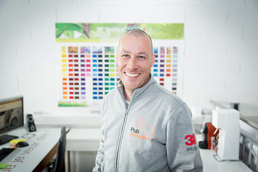 Homme souriant dans un bureau coloré.