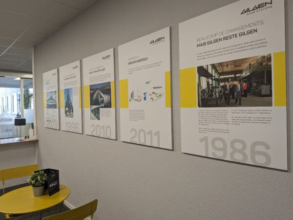 Exposition de panneaux historiques d'entreprise sur un mur.
