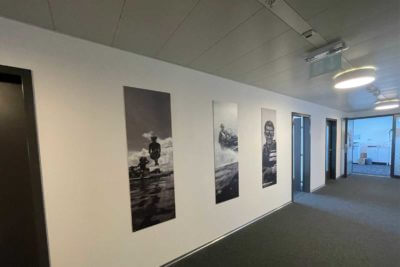 Couloir avec tableaux en noir et blanc sur mur.
