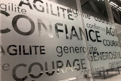 Mots positifs inscrits sur un mur de verre.