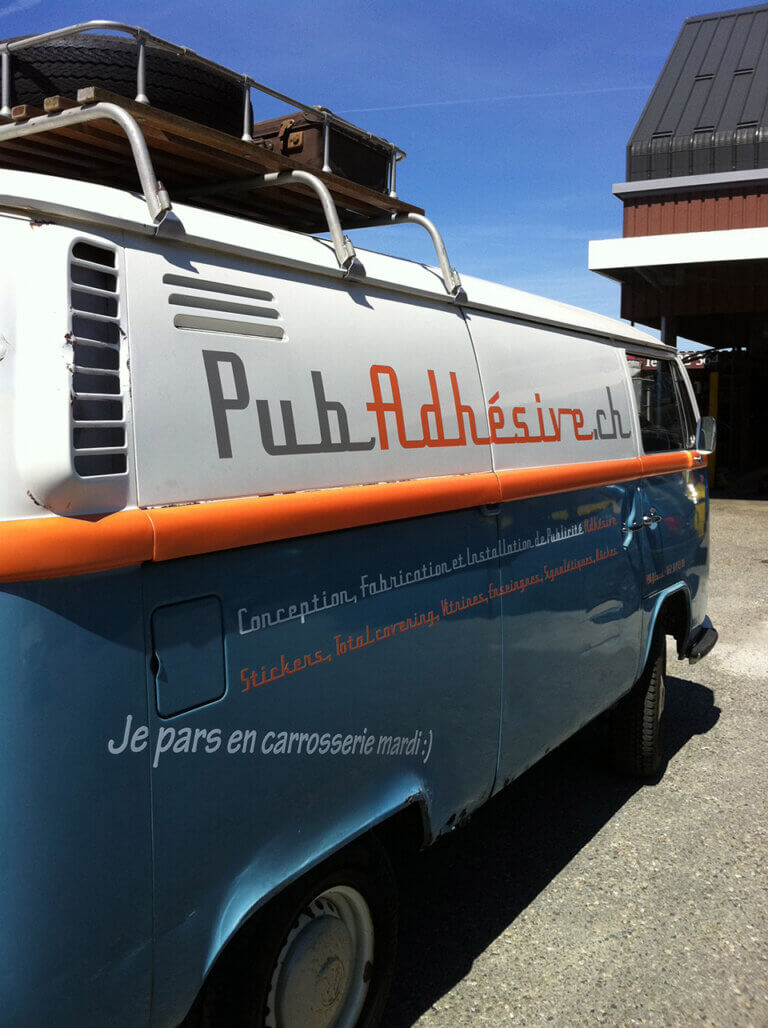 Combi vintage avec publicité adhésive, ciel bleu.