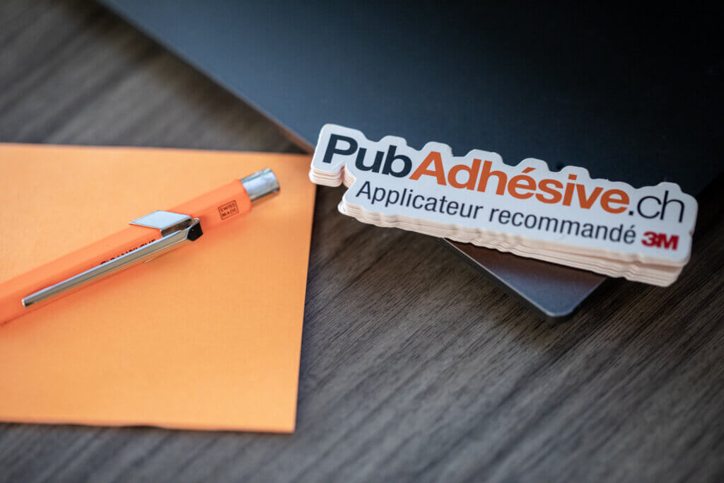 Stylo et autocollant PubAdhésive sur bureau