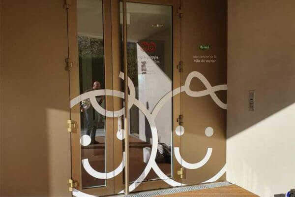 Porte en verre avec motifs souriants.