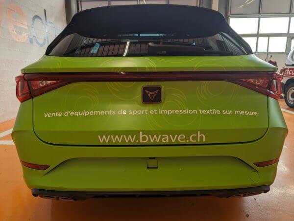 Voiture verte avec publicité de vente d'équipements sportifs.